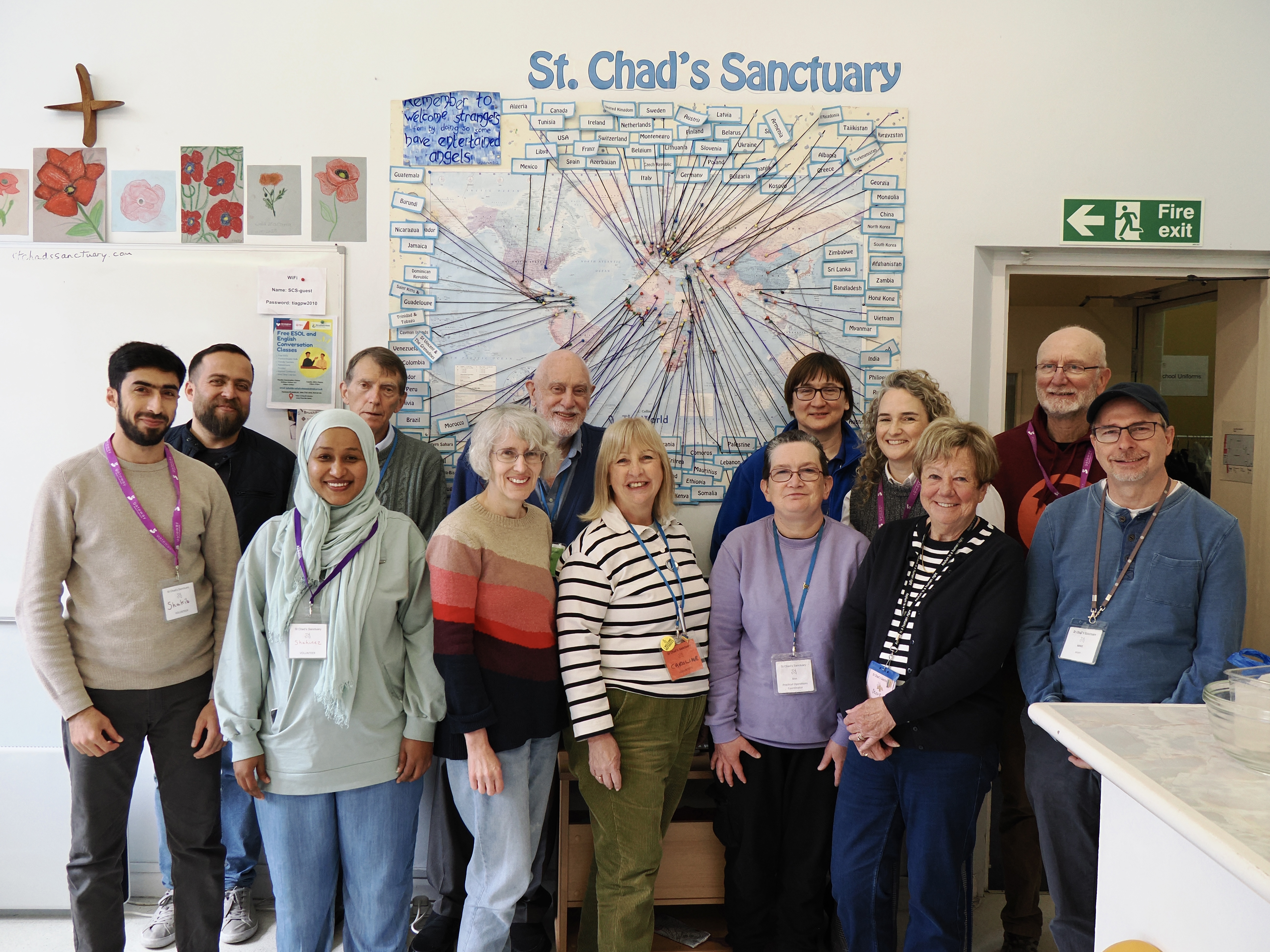 The St Chad's Sanctuary team standing together in front of a wall display under the St. Chad's Sanctuary sign.